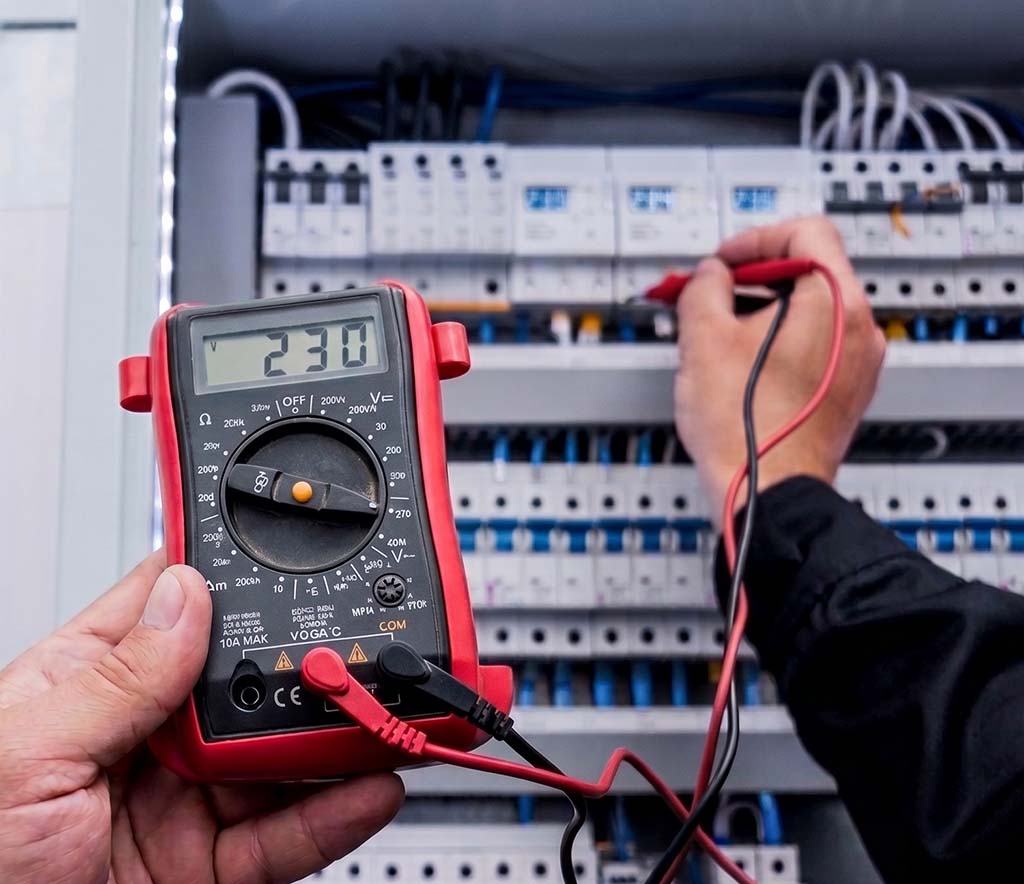 Revizní technik měří napětí multimetrem